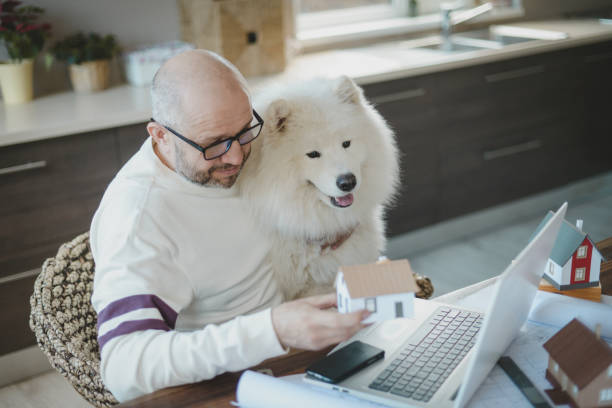 istock Mature adult man working at home with dog 1217162010