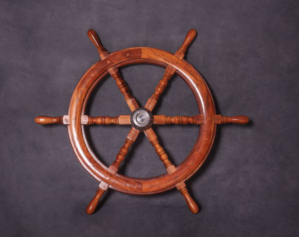 istock Wood marine steering wheel on a dark background 1217163270