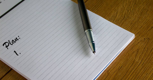 istock Notebook with the inscription plan and pen on wood table. 1217163399