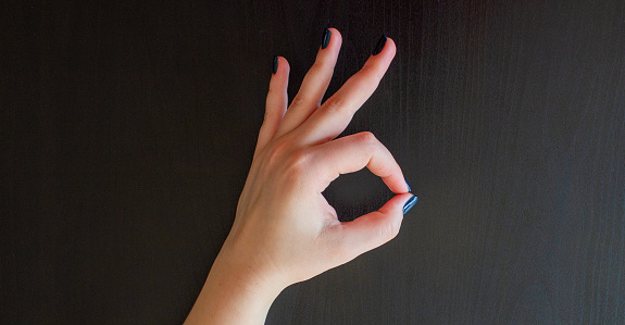 Woman's hand showing an Okay sign.