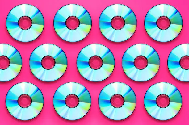 Photo of Shiny compact disk or DVD on pink background