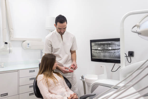 istock Doctor showing patient how clean teeth on jaw sample 1217166428