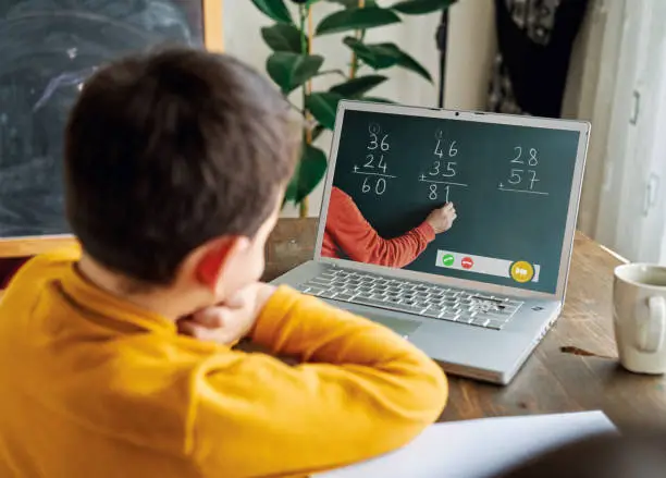 Photo of 6-7 years cute child learning mathematics from computer.