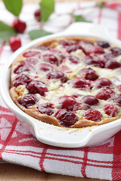 Sour cherry clafoutis in casserole dish fresh out of oven Clafoutis with sour cherry in the baking dish clafoutis stock pictures, royalty-free photos & images