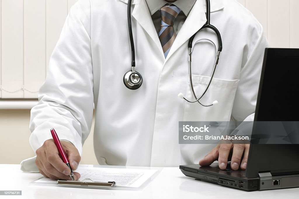 Writing a prescription or medical examination notes  Adult Stock Photo