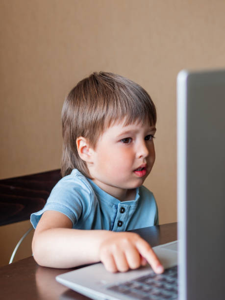 istock Curious toddler boy explores the laptop and presses buttons on computer keyboard. 1217168369