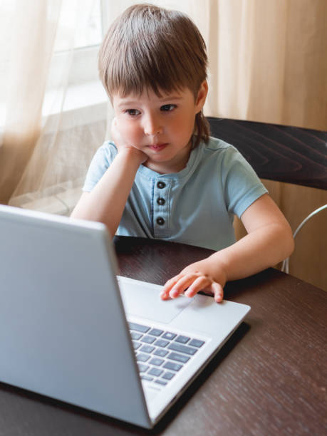 istock Curious toddler boy explores the laptop and presses buttons on computer keyboard. 1217168707