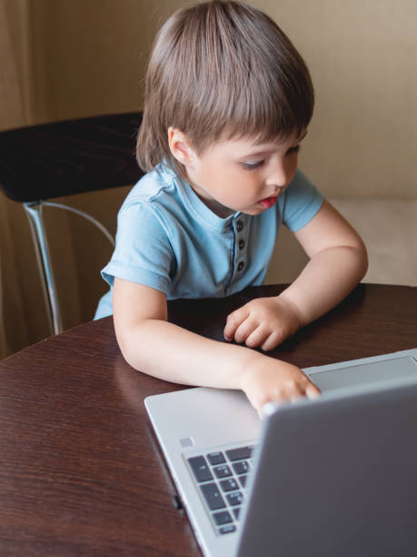 istock Curious toddler boy explores the laptop and presses buttons on computer keyboard. 1217169254