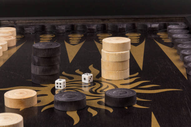istock Backgammon. Board game. White cubes and chips on a blackboard.  Dice on backgammon board game. Selective focus. Playing leisure games 1217170550