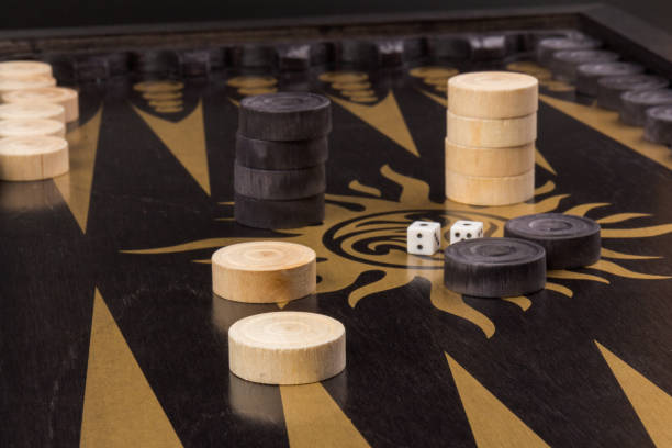 istock Backgammon. Board game. White cubes and chips on a blackboard.  Dice on backgammon board game. Selective focus. Playing leisure games 1217170599