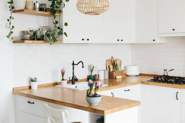 istock Modern white u-shaped kitchen in scandinavian style. Spring decoration spring flowers 1217171497