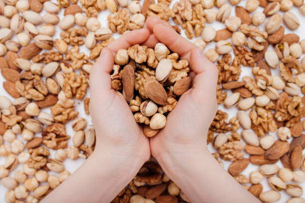 istock Assorted nuts in the child hands walnut, pistachio, almonds, Hazelnuts 1217172455