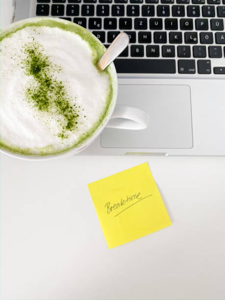Breaktime at the home Green Matcha latte cup on laptop.