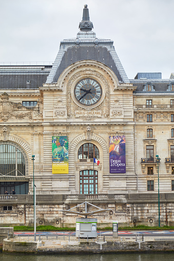 Paris, France - November 8, 2019: Gare D'Orsay or Orsay museum building facade and Seine river dock in a cloudy day in Paris