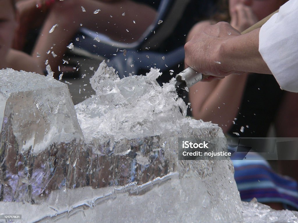 Ice sculptor chiseling a creation from a block of ice Ice sculpture being chiseled in front of out of onlookers Ice Stock Photo