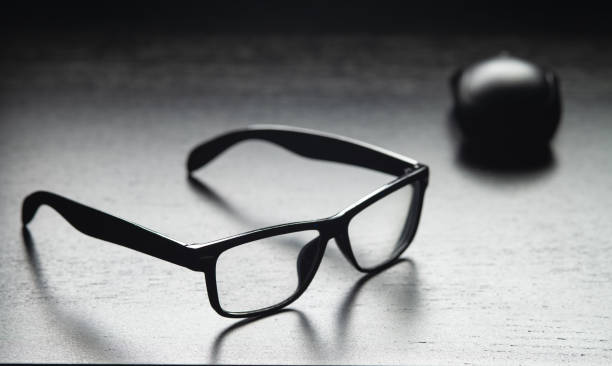 istock Black glasses and a phone lie on a black table 1217179275