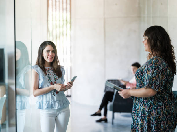 istock Female workers standing with phones and smiling 1217180893