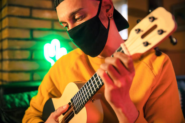 istock Young Men at Home During Quarantine Lockdown Learn Ukulele 1217182607