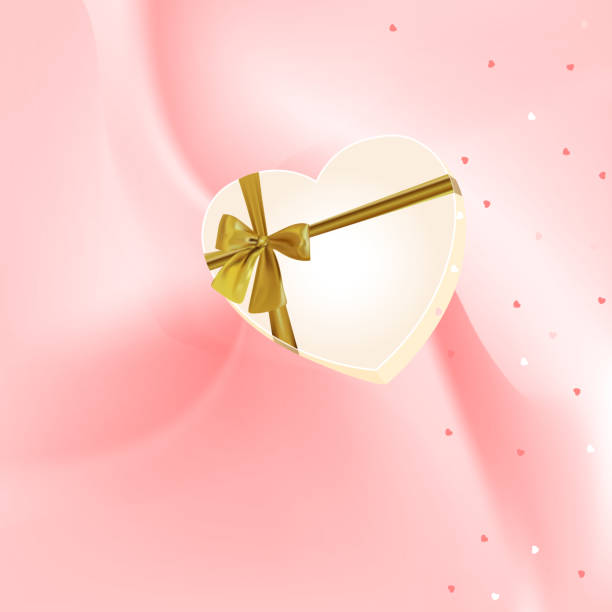 istock Beige box heart with gold bow on a pink blurred background. 1217182704