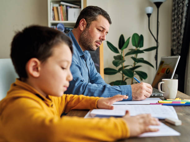 istock Businessman working at home with child. Child is making homework. 1217185115