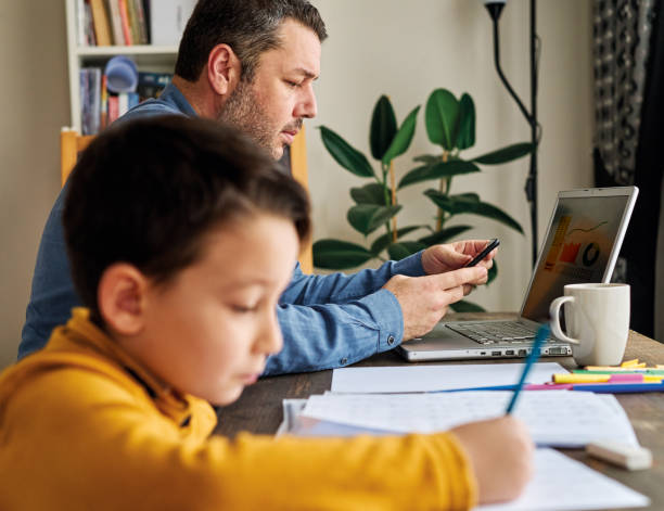 istock Businessman working at home with child. Child is making homework. 1217185307