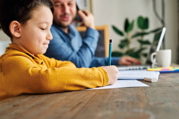 istock Businessman working at home with child. Child is making homework. 1217185365