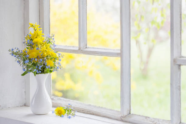 istock dandelions and forget-me-not in vase on windowsill 1217186420