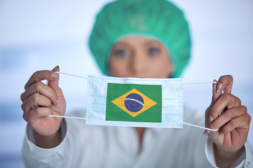 Brazil vs. Switzerland  two flags on flagpoles and blue cloudy sky background.Soccer matchday template