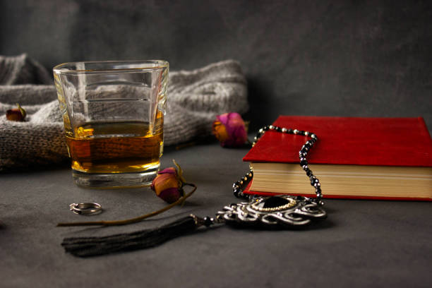 Moskovskaya oblast A glass of whiskey stands next to the book on which lies the decoration. moskovskaya stock pictures, royalty-free photos & images