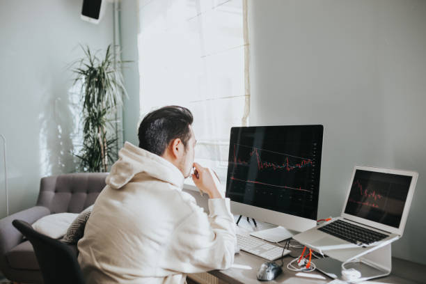 istock Japanese day trader looking at candlestick charts 1217191743