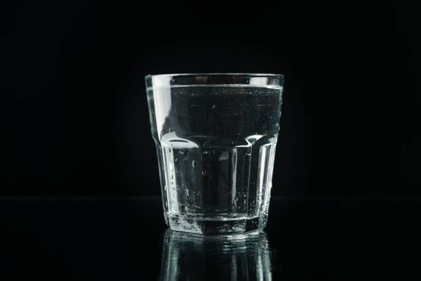 istock Purified fresh water in glass on mirror background 1217191885