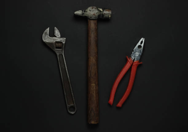 Wrench, hammer, pliers on a black background. Workers tools and instruments. Top view
