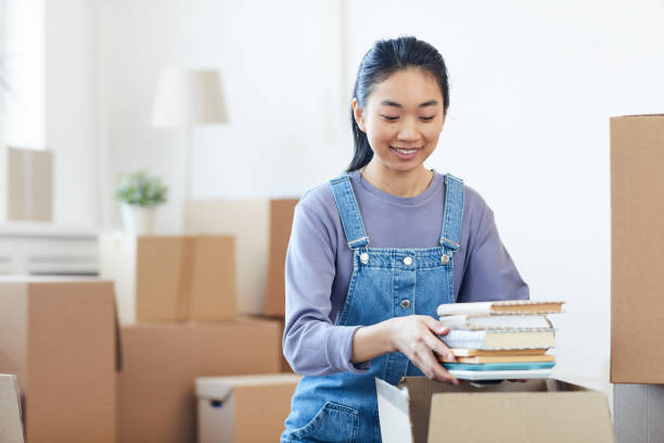 istock Young Asian Woman Packing Boxes 1217193532