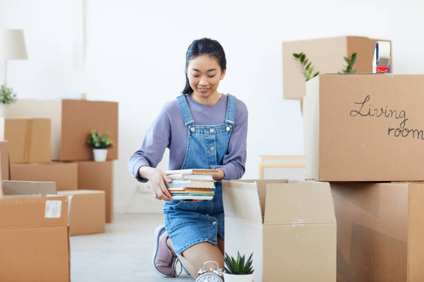 istock Young Asian Woman Unpacking Boxes 1217193539