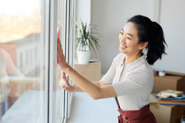 istock Young Asian Woman Cleaning Windows 1217193686