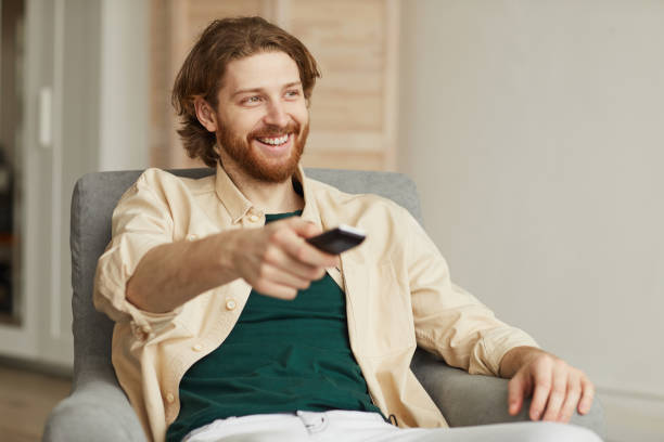 istock Handsome Bearded Man Watching TV at Home 1217195447
