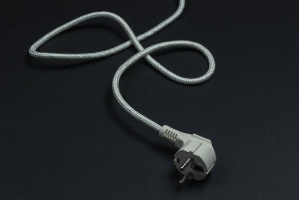 istock Electric plug with cable on a black background close-up 1217195584