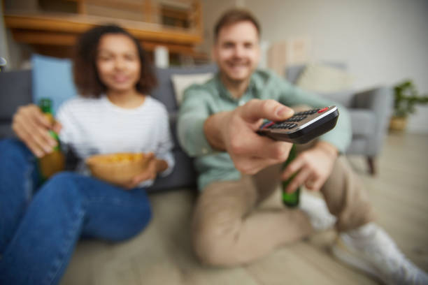 istock Couple Switching Channels on TV 1217195694