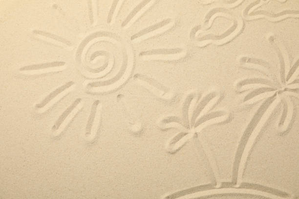 Sea sand with painted sun, clouds and palms on island