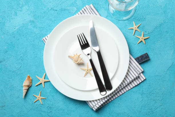 istock Table setting with seashells and starfishes on turquoise background, top view 1217199602