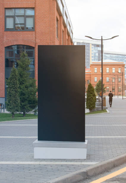 istock Blank black vertical pylon stand mockup brick building background 1217199805