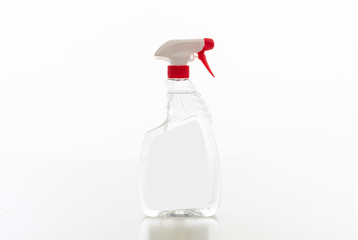 Cleaning spray bottle clear with red trigger isolated against white background. Chemical detergent product no name template, blank empty label, copy space