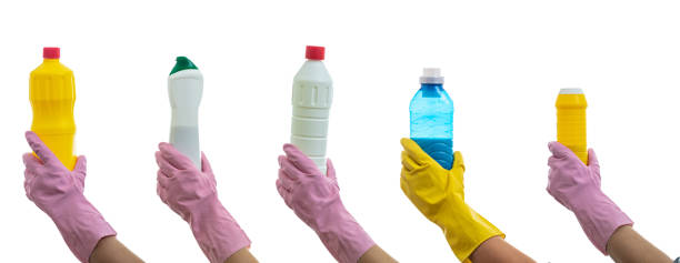 istock Cleaning bottles on gloved hands isolated against white background. 1217200438