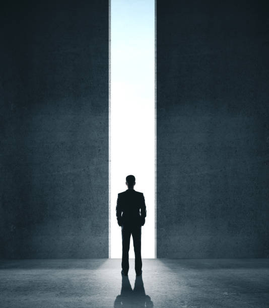 istock Businessman in concrete room with open door 1217200837