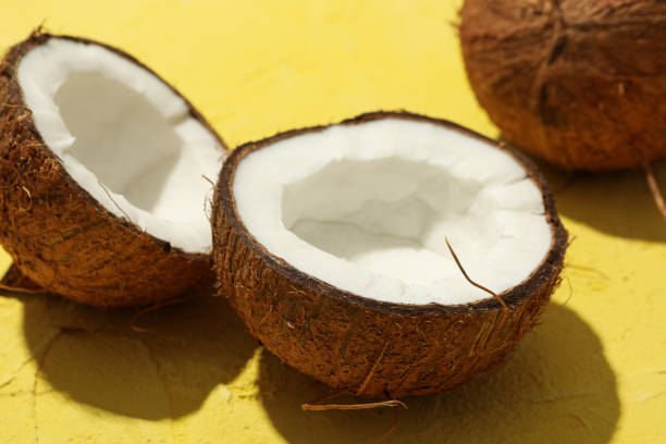 istock Coconut on yellow background, close up. Tropical fruit 1217200928