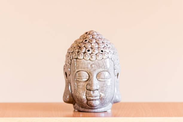 istock ceramic figurine of buddha head on beige background. 1217201318