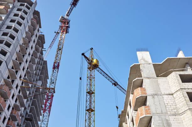istock Tower crane building a house. Concrete building under construction. Construction site 1217204814