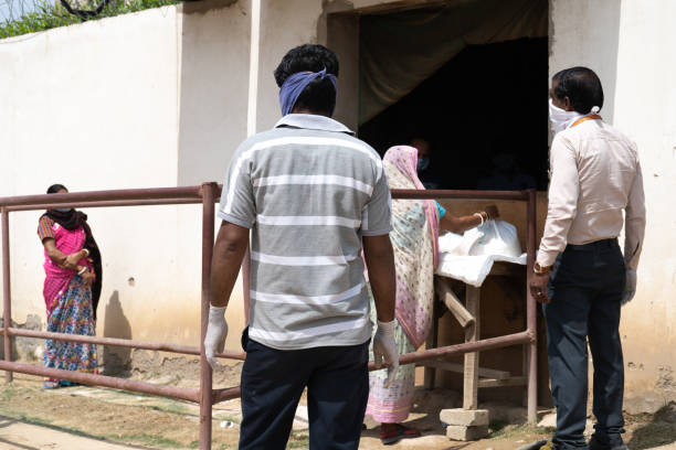 personas con máscaras que sirven comida a personas desfavorecidas como criadas, conductores, limpiadores de casas, etc. durante la pandemia de coronavirus en la india - underprivileged fotografías e imágenes de stock