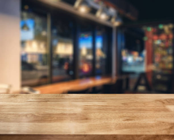 istock Striped wooden brown tabletop on glowing cafe at night 1217208111