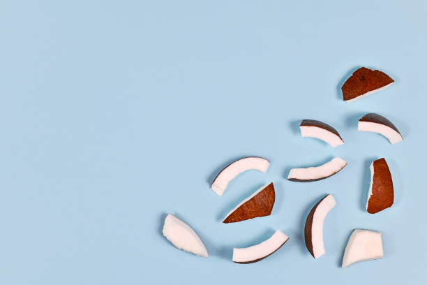 istock Cut pieces of coconut fruit in corner of light blue background with blank copy space 1217210251
